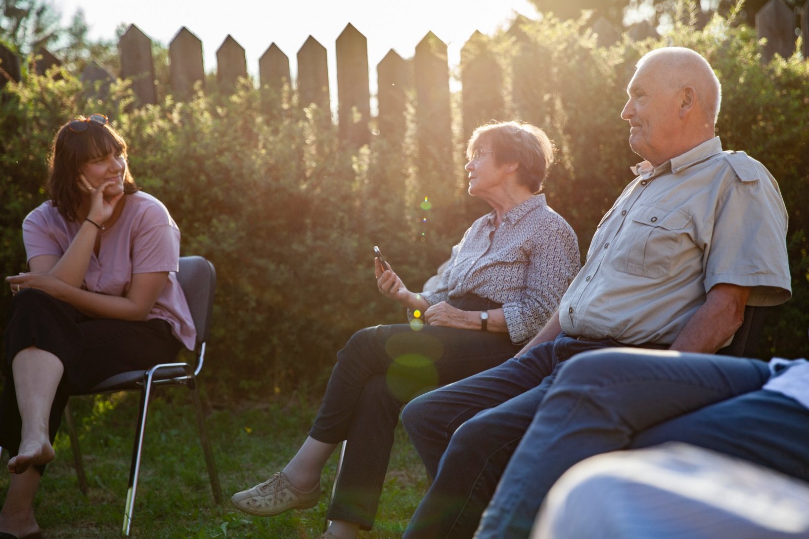 Mehrere Personen der Neuen Auftraggeber von Wietstock sitzen in der Abendsonne und sprechen miteinander