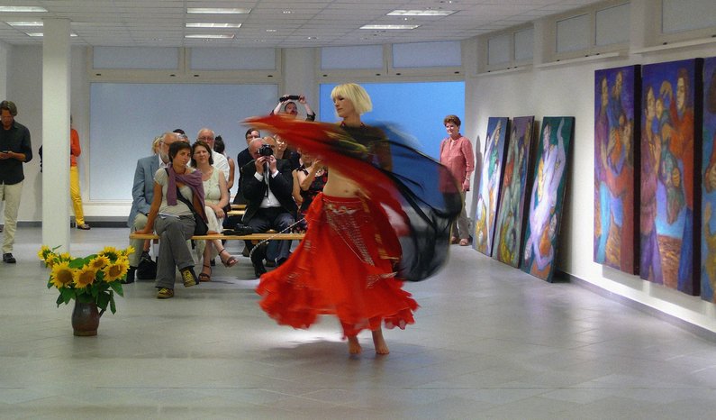 Ausstellungsraum mit mehreren Werken in Pritzwalk, eine Person tanzt in der Mitte des Raumes