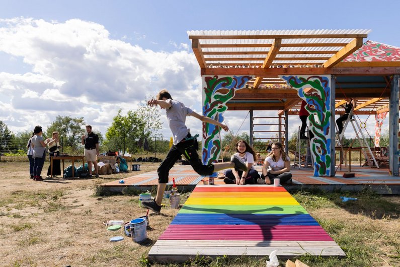 A student of the Seecampus Niederlausitz jumps over the coloured entrance of Casa Isadora in Schwarzheide