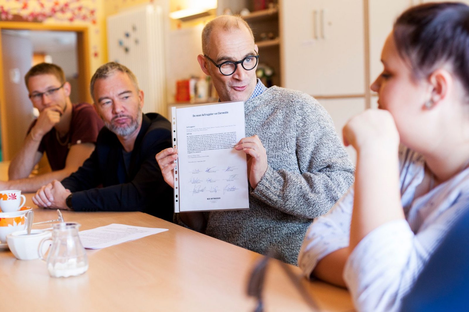 Mediator Holger Friese hält den unterzeichneten Auftrag von Eberswalde hoch