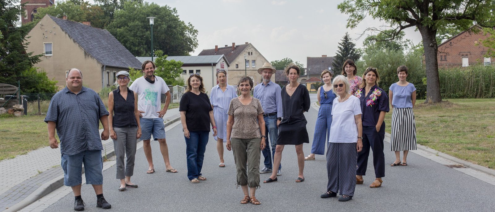 People standing on a street in village facing the observer