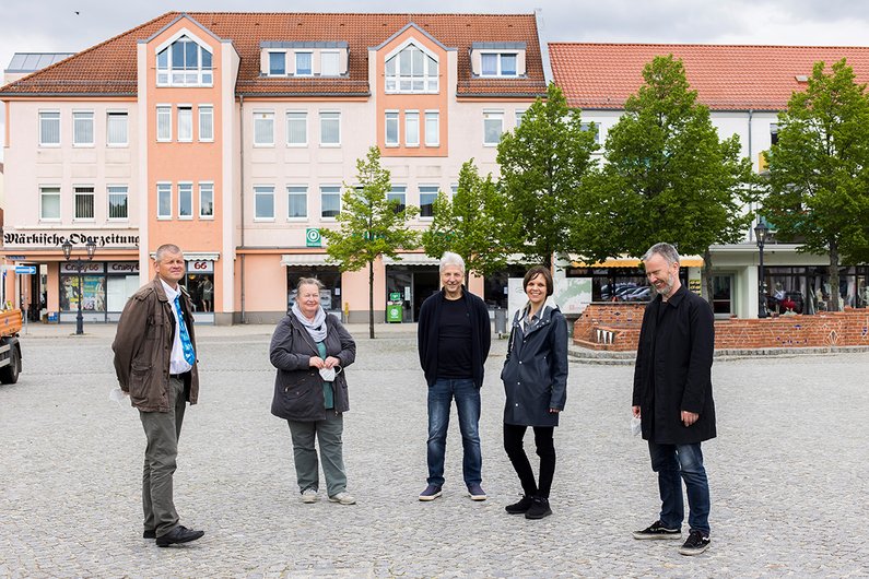 Mediator Lea Schleiffenbaum and Regional Manager Gerrit Gohlk stand with New Patrons in the market square of Beeskow