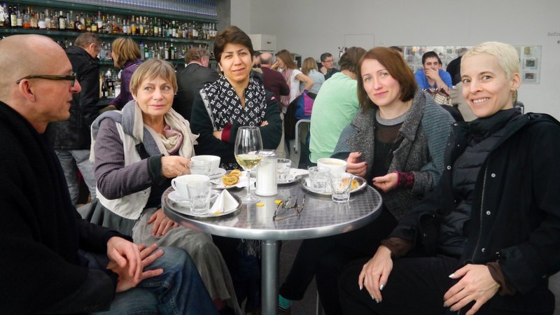 Artist Candice Breitz with Director of New Clients Alexander Koch with New Patrons group sitting in a café in Rostock