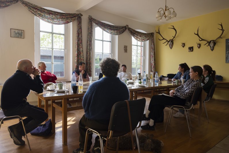 The New Patrons group of Sauen sitting around a large table at a meeting with Ateliers Pompiers 