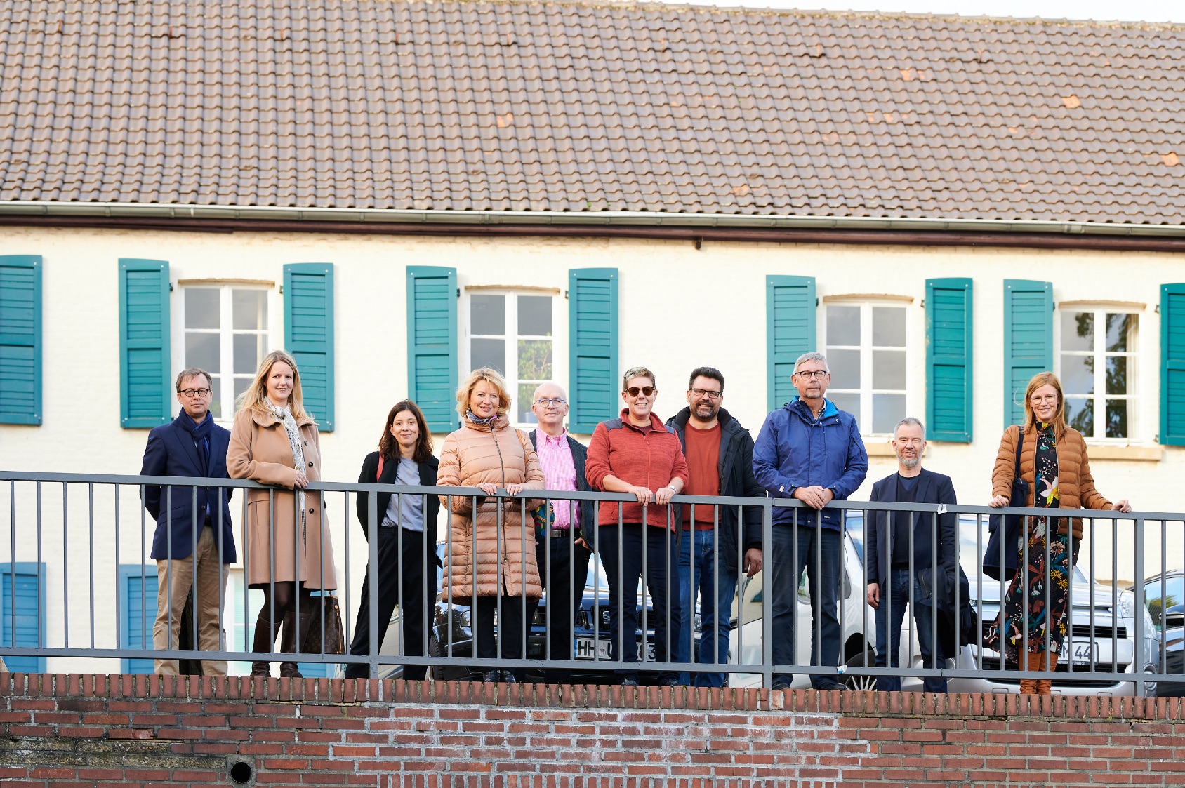 Group photo of the New Patrons of Wickrath in front of a building on the market square